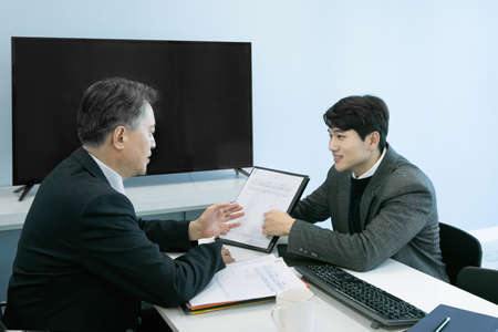business concept asian korean old and young two men, different generations male man boss and employee concept, talking, having a meeting on document, projectの写真素材