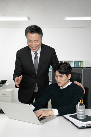 business concept asian korean old and young two men, different generations male man boss and employee concept, working with laptopの写真素材