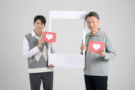 asian korean old and young two men holding frameの写真素材