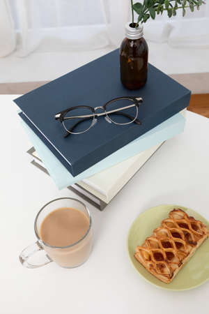 relax cozy objects and background with milk tea, a book, glasses, pie, diffuser