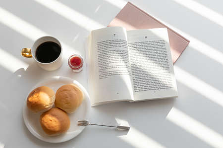 relax cozy objects and background with bread, coffee, candle, a bookの写真素材