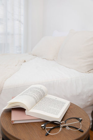 relax cozy objects and background with glasses, a book, bedding, haling timeの写真素材