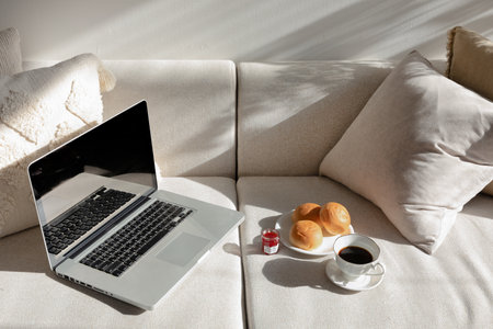 relax cozy objects and background with sofa and cushion, laptop bread and coffeeの写真素材