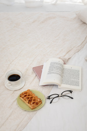 relax cozy objects and background with a book, pie, beddingの写真素材