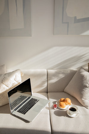 relax cozy objects and background with sofa and cushion, laptop bread and coffeeの写真素材