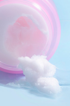 isolated smear beauty cosmetics texture of cleansing balm, spatula in blue background