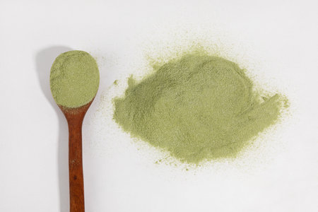 Matcha green tea powder and spoon in white backgroundの写真素材