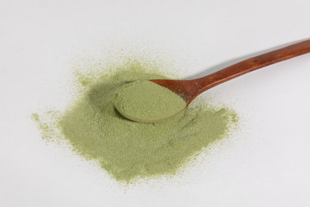 Matcha green tea powder and spoon in white backgroundの写真素材