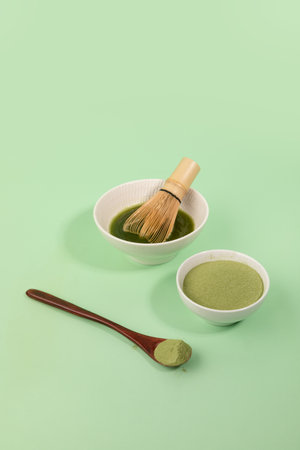 melting matcha green tea powder in water to make green tea drinkの写真素材