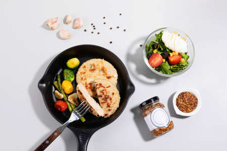 a steak made of chicken breast and salad, white background