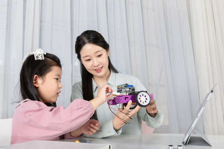 Asian Korean mother and daughter assembling toy cars