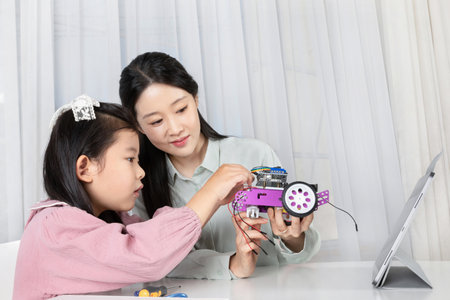 Asian Korean mother and daughter assembling toy carsの写真素材