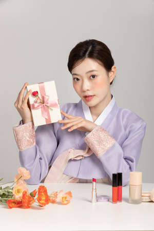 spring beauty concept, beautiful korean woman wearing hanbok with holding giftの写真素材
