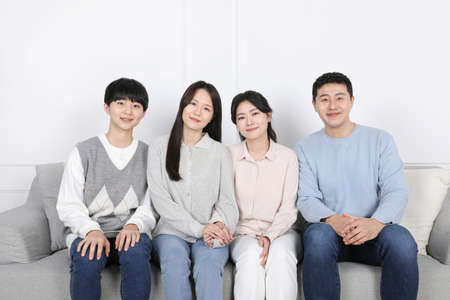 Asian Korean family_Photo of a smiling family sitting side by sideの写真素材