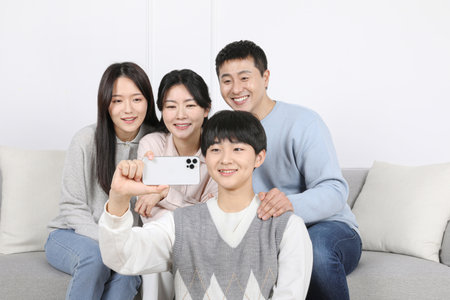 Asian Korean Family_Photo of a family watching a video on a smartphone togetherの写真素材