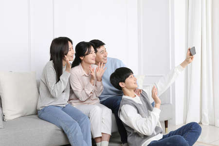 Asian Korean Family_Photo of a family having a video call togetherの写真素材