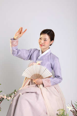 spring beauty concept, beautiful korean woman wearing hanbok with folding panの写真素材