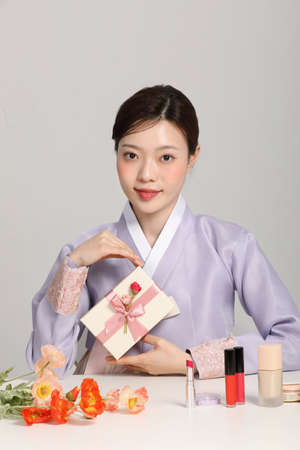 spring beauty concept, beautiful korean woman wearing hanbok with holding giftの写真素材
