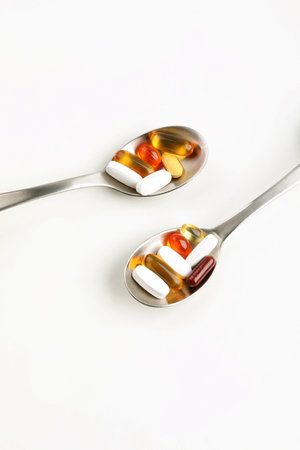 a wooden spoon and pills, white background, medical creative concept photo