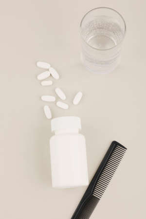 hair brush and pills, white background, medical creative concept photoの写真素材