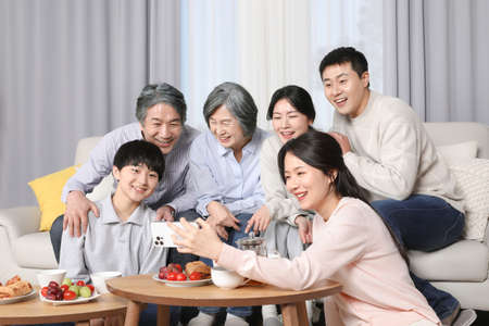 Asian Korean Family_Watching video on cell phoneの写真素材