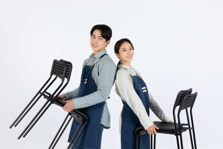 Asian Korean young man and woman startup concept_ tidying up their chairsの写真素材