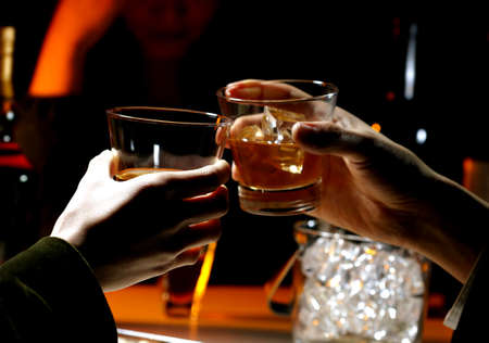 People toasting over whiskey glasses