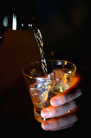 Person pouring a cup of whiskey