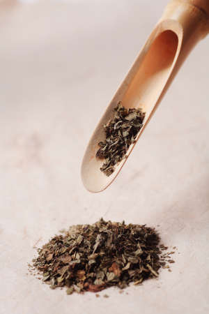 Dried tea leaves in a bamboo scoop