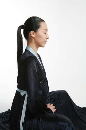 Asian dancer in black traditional korean costume meditating before her performance