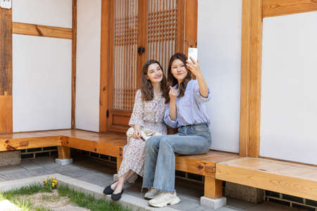 Experience Hanok, Korean traditional house_Korean and Caucasian girls taking a photoの写真素材