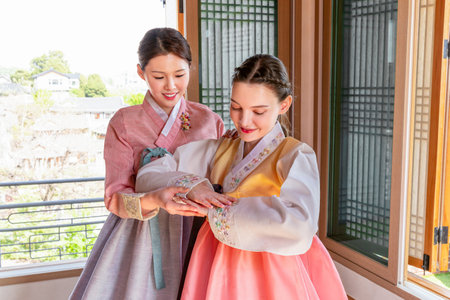 Experiencing Korean traditions in Hanok_Korean girl teaching Caucasian girl how to bowの写真素材
