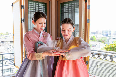 Experiencing Korean traditions in Hanok_Korean girl teaching Caucasian girl how to bowの写真素材