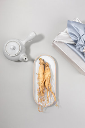 oriental, medicinal root plant, fresh ginseng wrapped in silk cloth for giftの写真素材