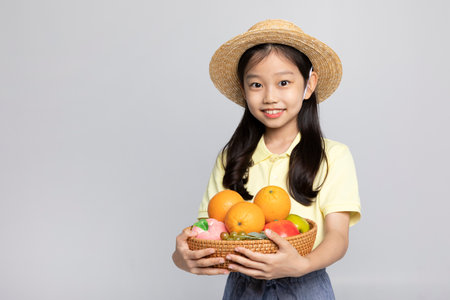 Korean young girl wearing gym clothes in white background studio__holding a fruit basketの写真素材