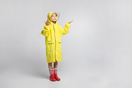 cute young Korean girl, rainy season concept in white background studio__looking up the sky with reaching out handの写真素材