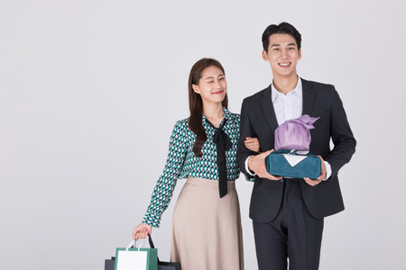 Korean young couple, man and woman wearing modern Hanbok_holding paper bag and gift boxの写真素材