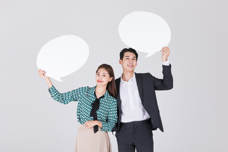 Korean young couple, man and woman wearing modern Hanbok_holidng speech bubble panelの写真素材