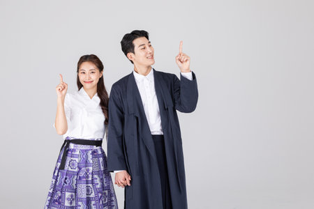 Korean young couple, man and woman wearing modern Hanbok_pointing in the directionの写真素材