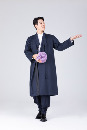 goodlooking Korean young man in 20s wearing modern Hanbok wearing hanbok_holding traditional boxの写真素材