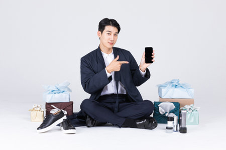 goodlooking Korean young man in 20s wearing modern Hanbok wearing hanbok_sitting man with traditional box and man's cosmetic and shoesの写真素材