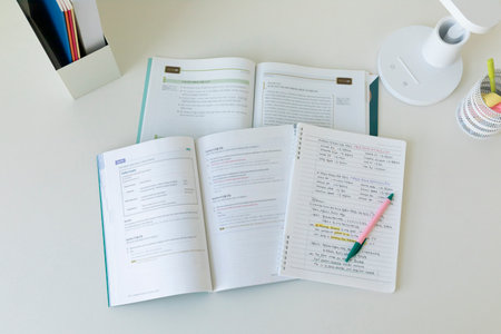 studying at home, study desk setup_handwriting notes and open workbooks