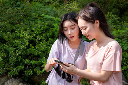 korean young women hiking and plogging_find directions using smartphoneの写真素材