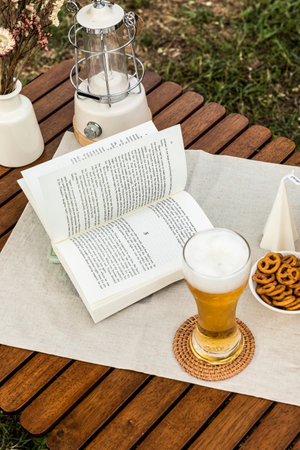 camping mood aesthetics_drinking beer with reading a bookの写真素材