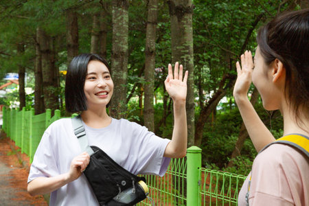 korean young women hiking and plogging_greeting each otherの写真素材