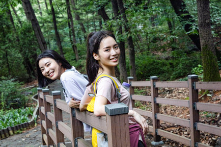 korean young women hiking and plogging_resting against the railの写真素材