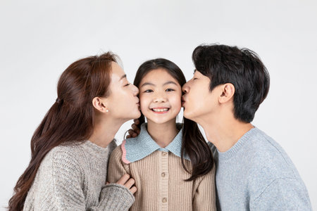 happy Asian Korean family, isolated in white background-kissing to daughterの写真素材