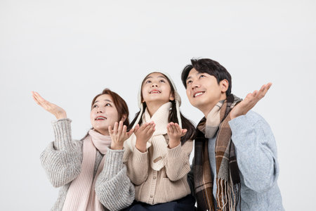 happy Asian Korean family, isolated in white background-holding a snowflakeの写真素材