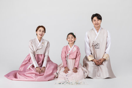 Korean family in Hanbok, isolated white background-sitting side by sideの写真素材