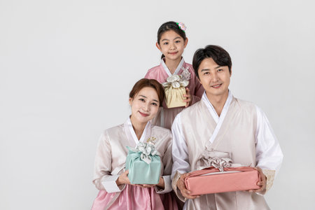 Korean family in Hanbok, isolated white background-holding a presents